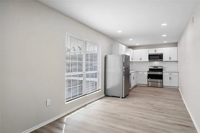 a view of kitchen with stainless steel appliances refrigerator oven microwave and cabinets