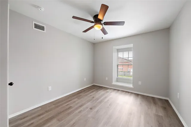 wooden floor in an empty room with a window