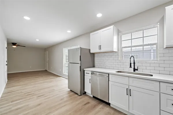 a kitchen with a sink a refrigerator and window