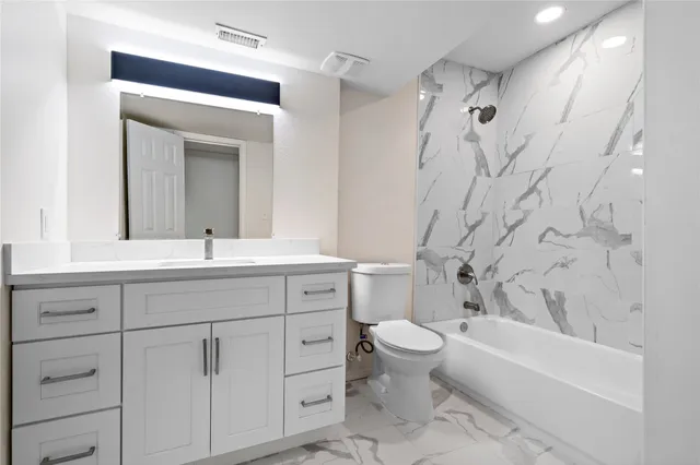 a bathroom with a double vanity sink toilet mirror and bathtub