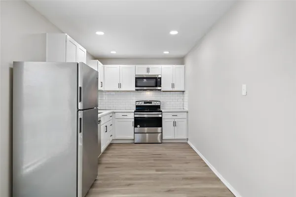 a kitchen with a refrigerator stove and microwave