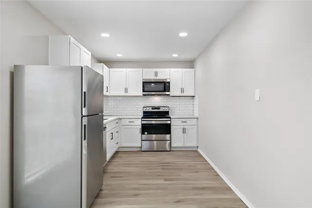 a kitchen with a refrigerator stove and microwave