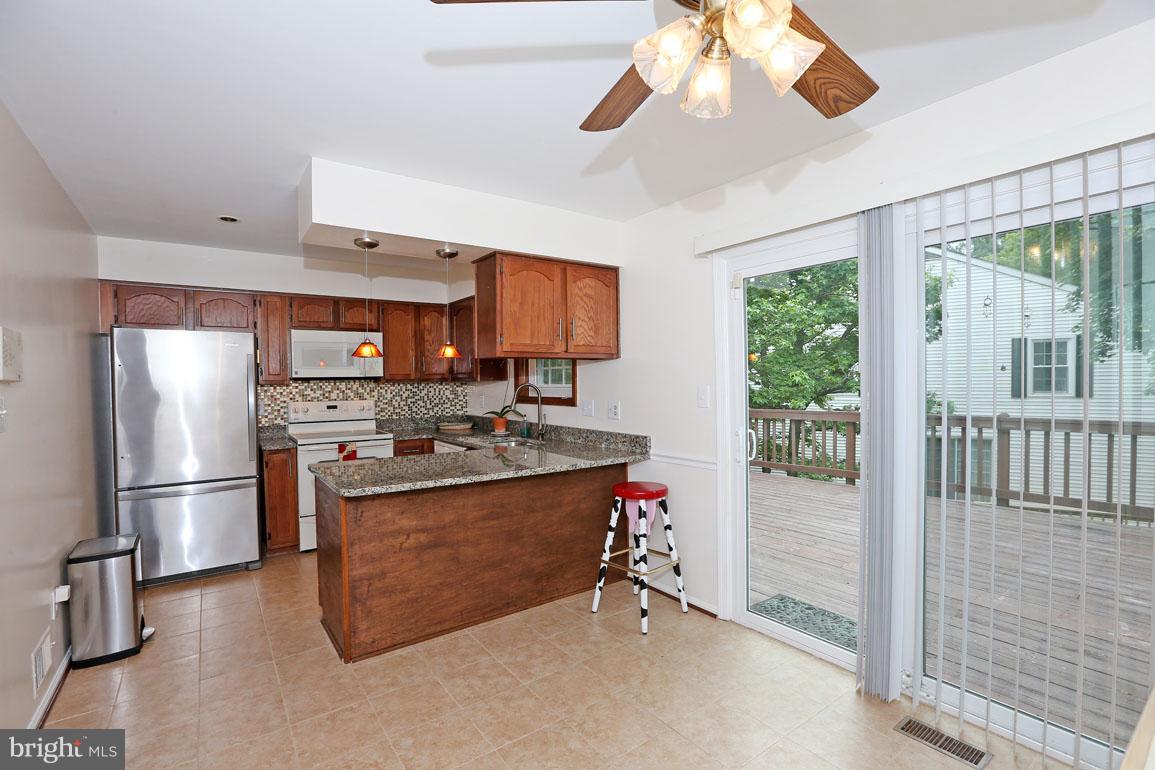 1725 Logmill Lane Gaithersburg, MD 20879 - Photo 11 of 30 a kitchen with stainless steel appliances granite countertop a stove and a refrigerator