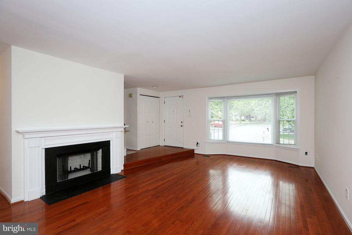 1725 Logmill Lane Gaithersburg, MD 20879 - Photo 5 of 30 a view of empty room with wooden floor and fireplace