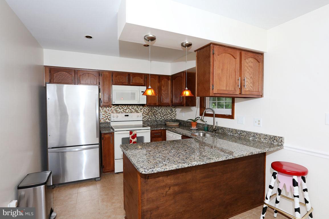 1725 Logmill Lane Gaithersburg, MD 20879 - Photo 8 of 30 a kitchen with granite countertop a refrigerator and a sink