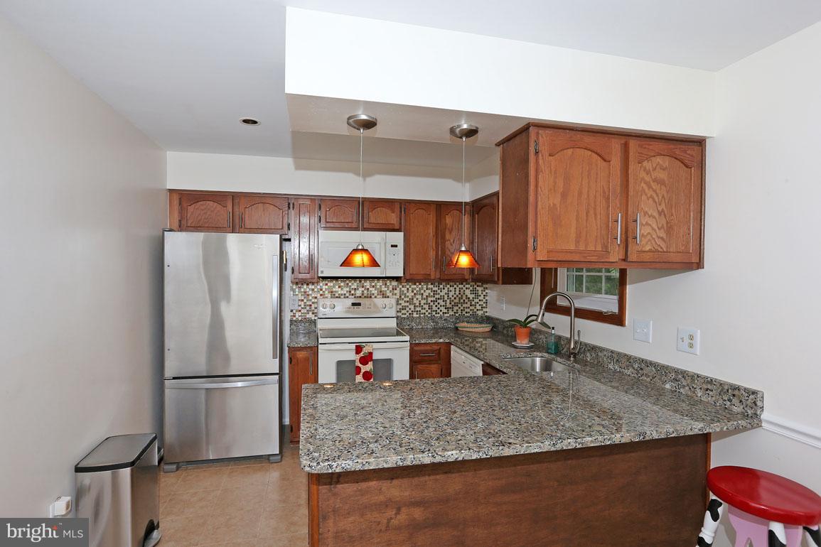 1725 Logmill Lane Gaithersburg, MD 20879 - Photo 9 of 30 a kitchen with stainless steel appliances granite countertop a sink and a refrigerator