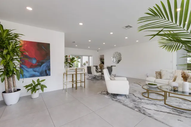 a living room with furniture kitchen view and a large window