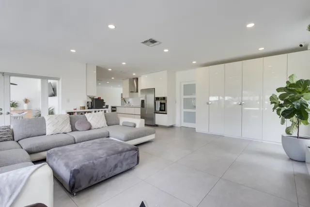 a bedroom with a flat screen tv on the dresser and a potted plant
