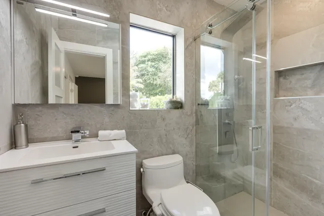 a bathroom with a sink toilet double vanity and shower