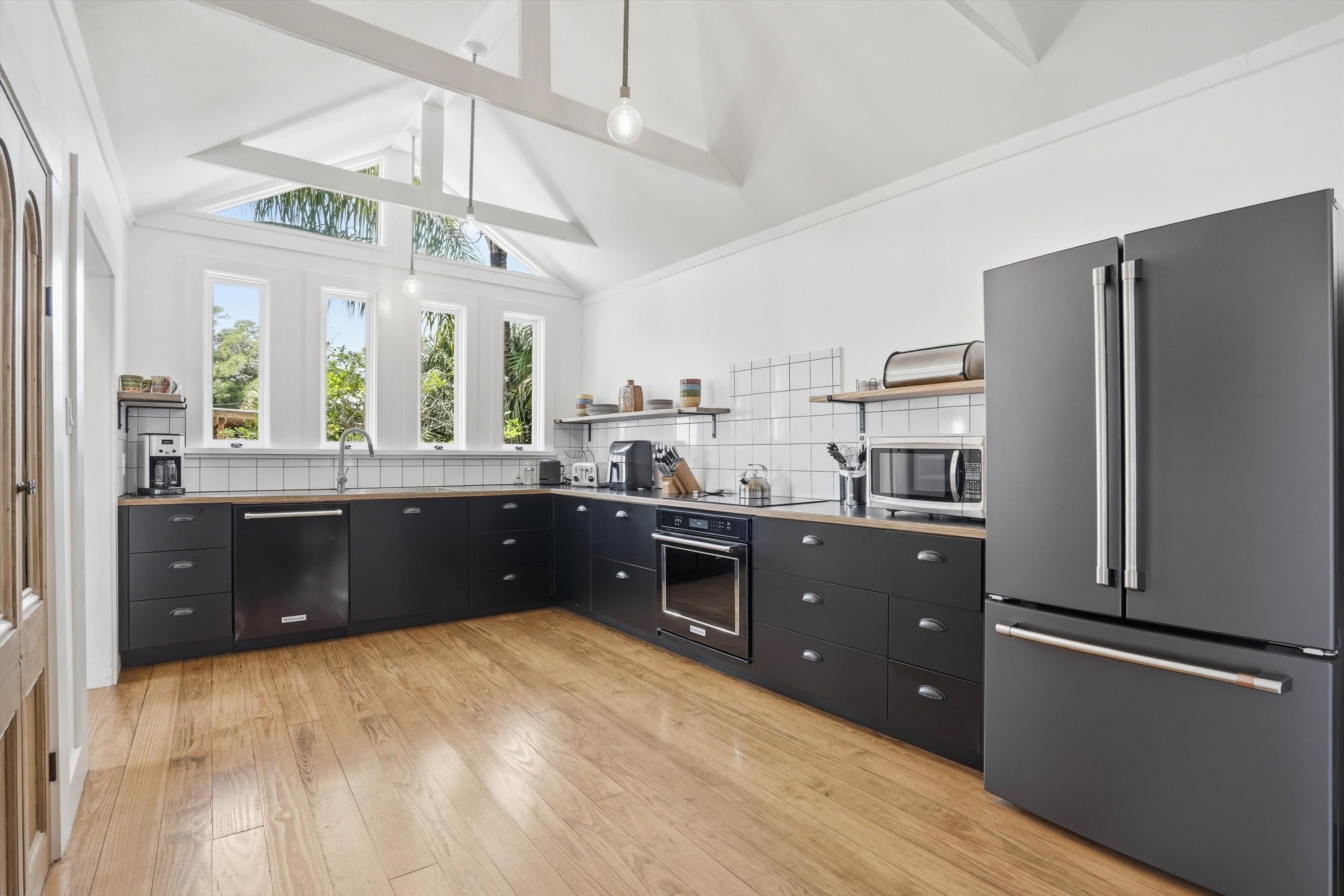 76 Oneida Street St. Augustine, FL 32084 - Photo 14 of 38 a open kitchen with stainless steel appliances granite countertop a refrigerator a sink dishwasher a stove and white countertops with wooden floor