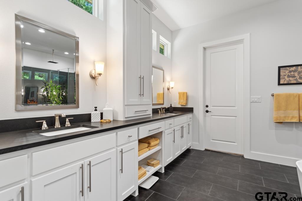 2926 Stewart Way Tyler, TX 75709 - Photo 18 of 33 a spacious bathroom with a double vanity sink and a mirror