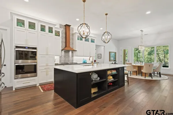 a kitchen with a large counter space wooden floor and stainless steel appliances