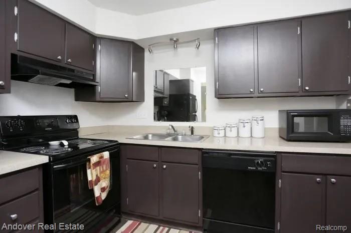 312 South Drake Road Kalamazoo, MI 49009 - Photo 1 of 21 Kitchen featuring dark wood-finish cabinetry, light-toned countertops, and a stainless steel double basin sink