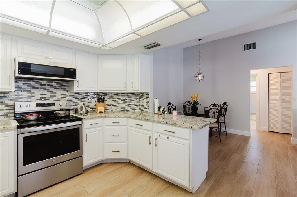8112 Golden Bear Loop Port Richey, FL 34668 - Photo 26 of 88 a kitchen with a stove oven and white cabinets