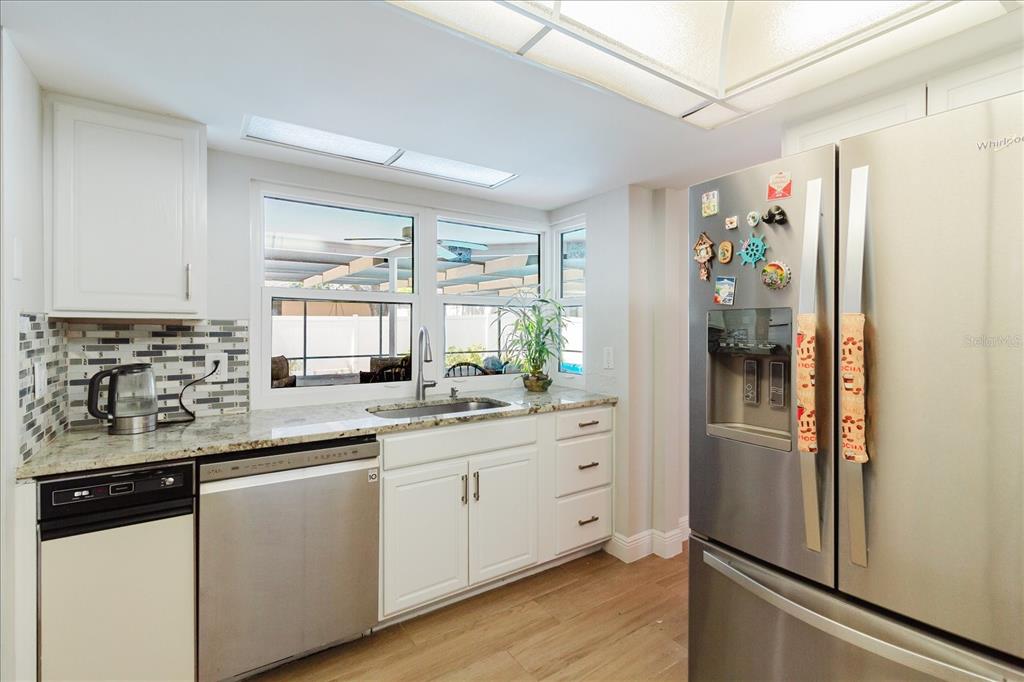 8112 Golden Bear Loop Port Richey, FL 34668 - Photo 28 of 88 a kitchen with stainless steel appliances a refrigerator sink and cabinets