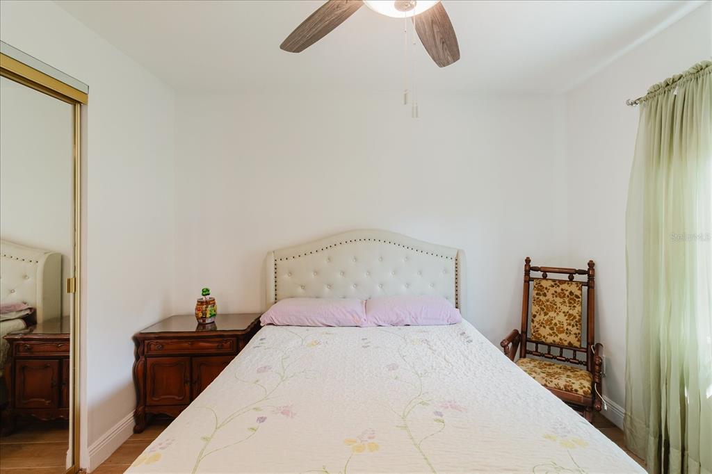 8112 Golden Bear Loop Port Richey, FL 34668 - Photo 48 of 88 a bedroom with a bed and a chandelier