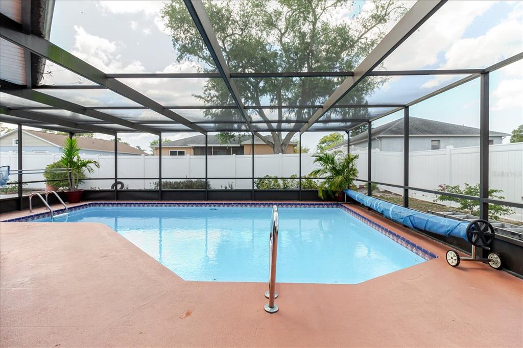 8112 Golden Bear Loop Port Richey, FL 34668 - Photo 62 of 88 a view of a swimming pool with a bench and wooden fence