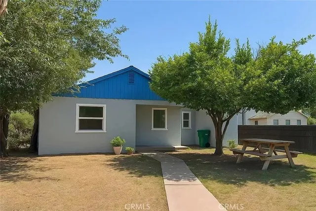 a view of a house with backyard and sitting area