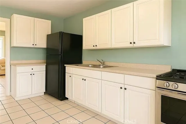 a kitchen with stainless steel appliances white cabinets and a refrigerator