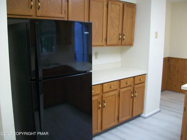 a kitchen with stainless steel appliances granite countertop white cabinets and a refrigerator