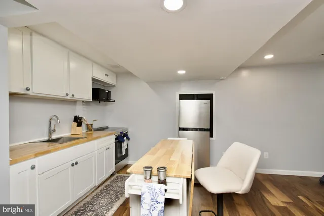 a large white kitchen with sink and cabinets