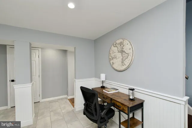 a living room with dining table a clock and a window