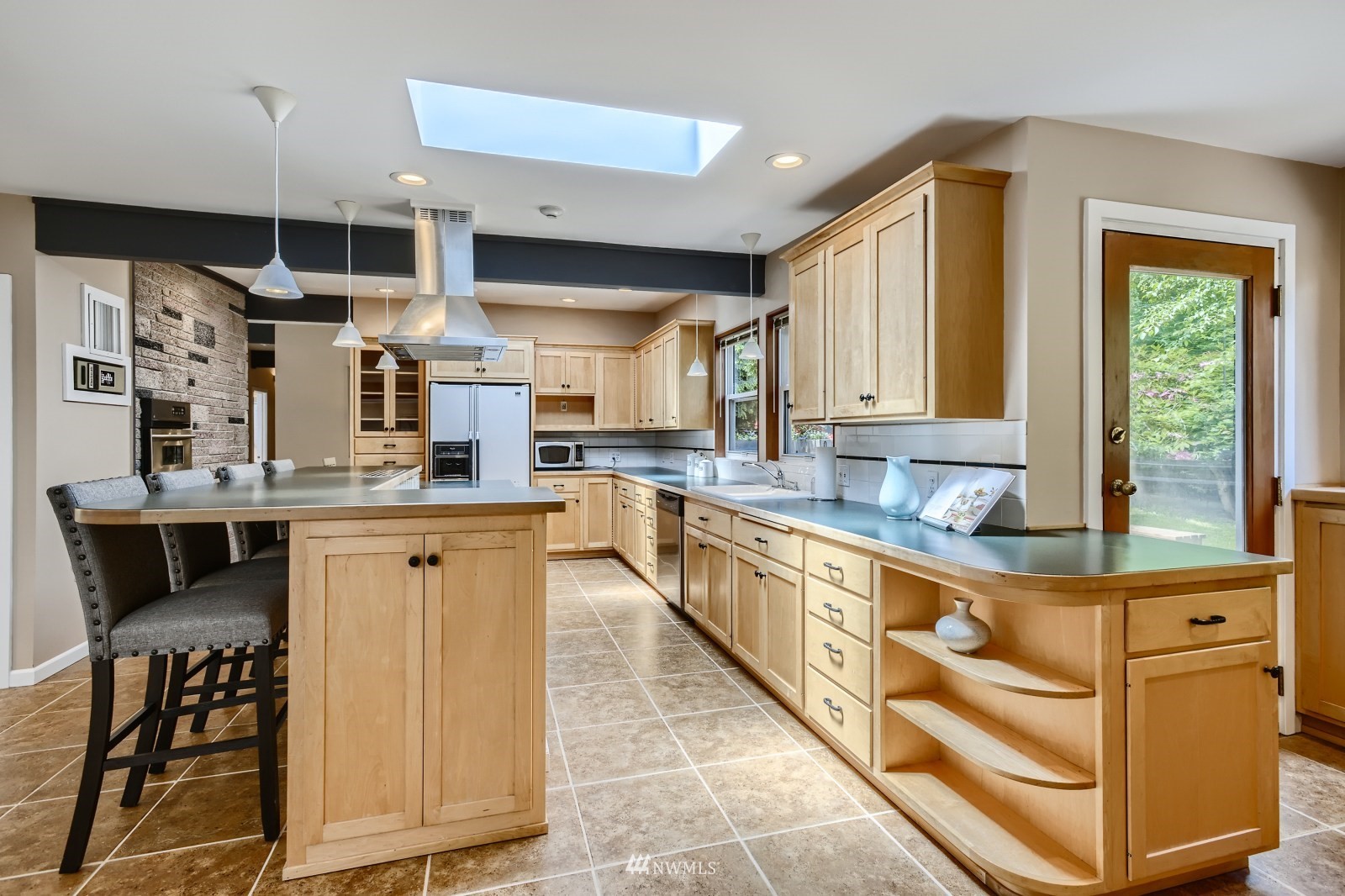 2207 242nd Street Southwest Bothell, WA 98021 - Photo 8 of 28 a kitchen with stainless steel appliances kitchen island granite countertop a refrigerator and cabinets