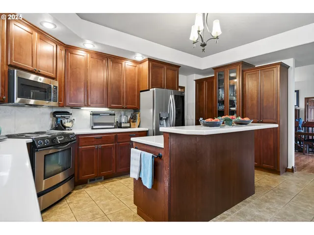 a kitchen with stainless steel appliances granite countertop a refrigerator a stove a sink dishwasher and a microwave oven with cabinets