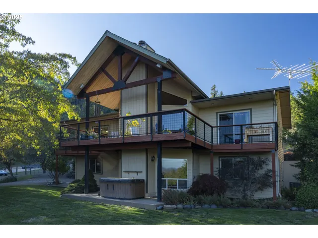 a view of a house with wooden deck and a yard