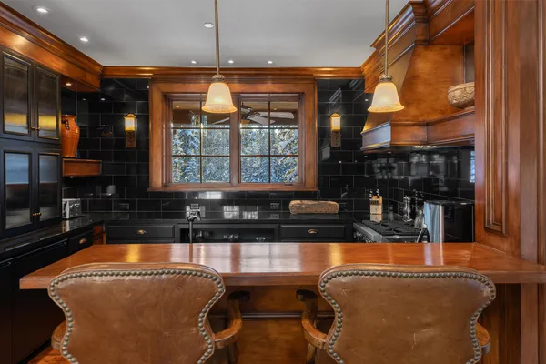 a outdoor kitchen with granite countertop a stove and white cabinets
