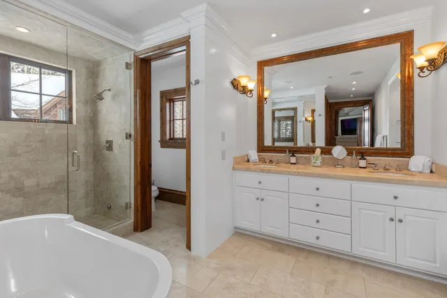 a spacious bathroom with a double vanity sink a mirror and a bathtub