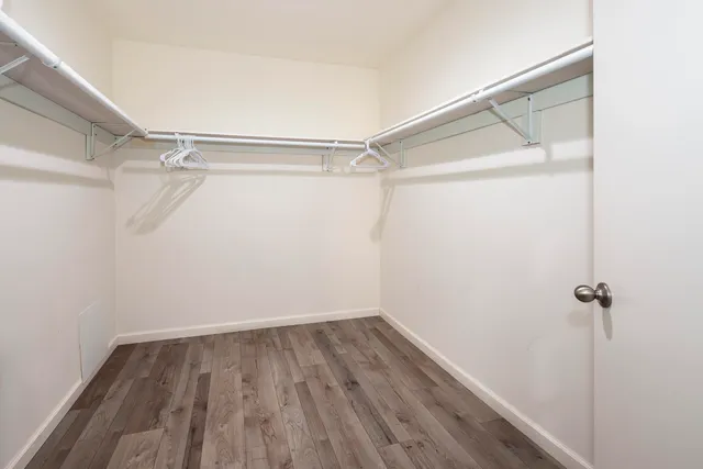 a view of a room with wooden floor and fan