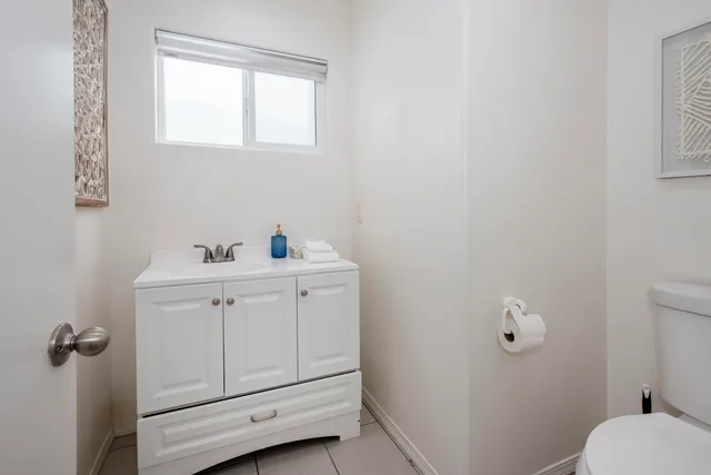 a bathroom with a sink a toilet and window