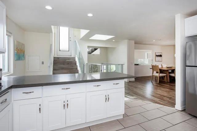 a kitchen with white cabinets and chandelier