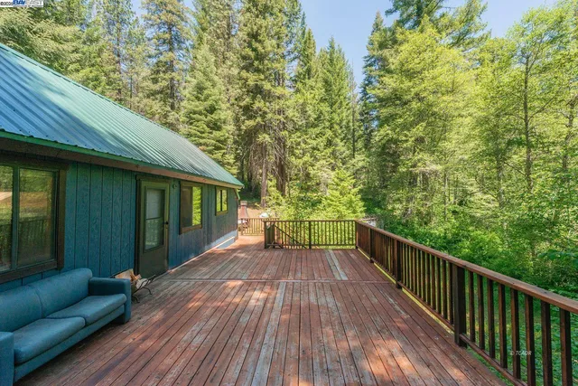 a view of house with a yard and deck
