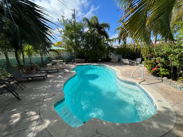 a swimming pool with outdoor seating and trees