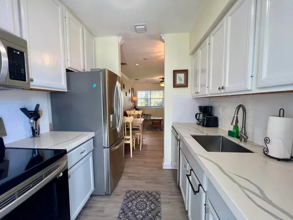 a kitchen with granite countertop a sink stainless steel appliances and cabinets