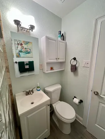 a bathroom with a toilet sink and mirror