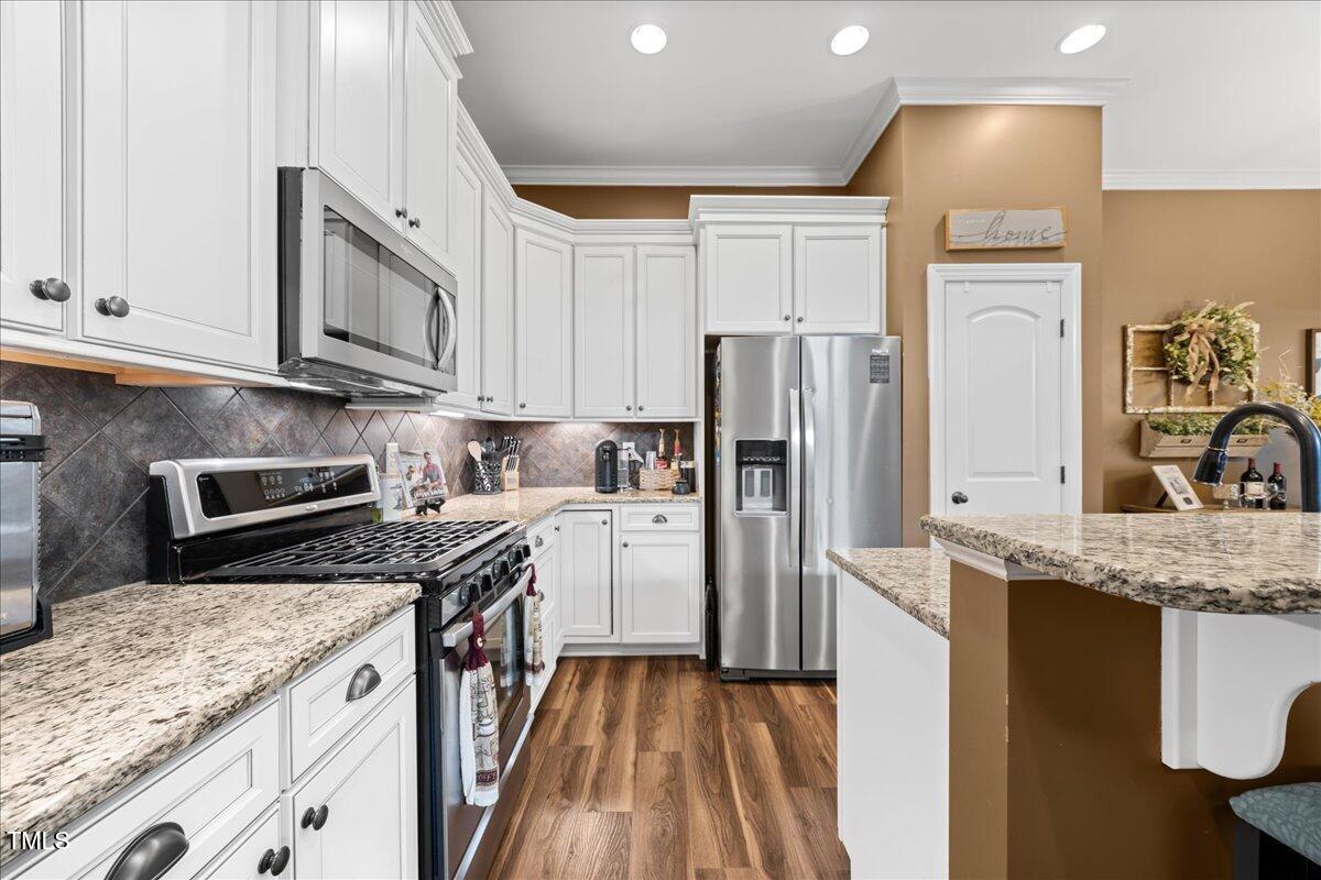 1300 Formal Garden Way Raleigh, NC 27603 - Photo 12 of 45 a kitchen with stainless steel appliances granite countertop a refrigerator a stove and a sink