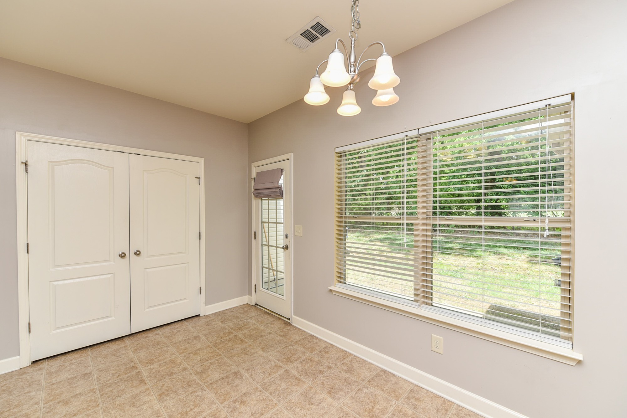 735 Tulip Grove Road, Unit 311 Hermitage, TN 37076 - Photo 11 of 35 a view of a livingroom with a chandelier curtains and large windows