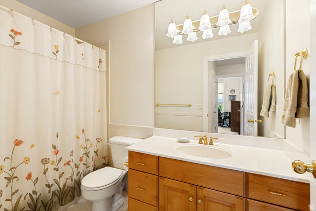 298 North Canyon Road Bountiful, UT 84010 - Photo 24 of 57 Bathroom featuring a wood-finish vanity with a built-in sink, a large wall-mounted mirror, and a multi-bulb light fixture
