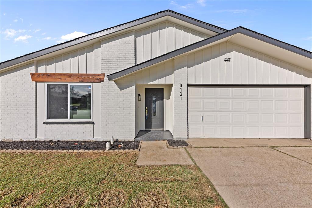 3121 Wayfarer Road Bedford, TX 76021 - Photo 1 of 32 View of front of property featuring a garage, driveway, brick siding, a front yard, and board and batten siding