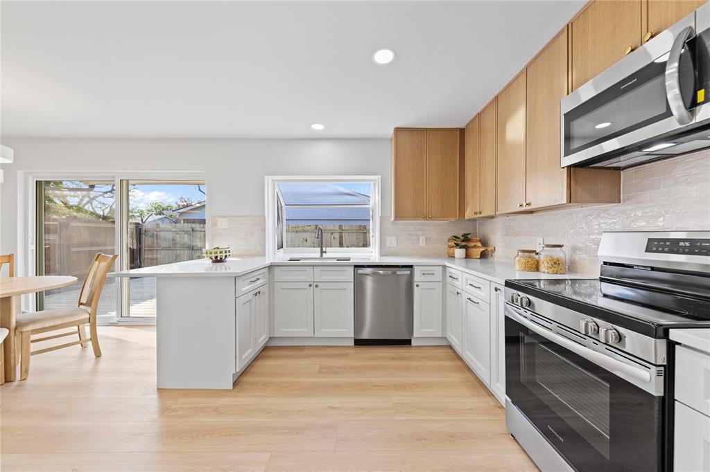 3121 Wayfarer Road Bedford, TX 76021 - Photo 13 of 32 Kitchen featuring stainless steel appliances, a peninsula, light wood finished floors, decorative backsplash, and recessed lighting