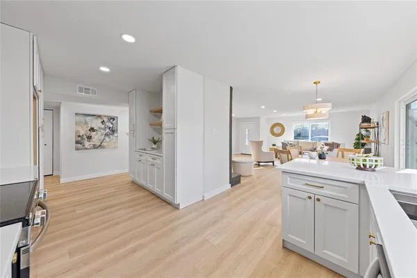 a kitchen with white cabinets and stainless steel appliances