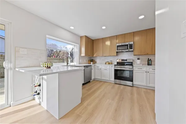 a kitchen with a sink a counter top space stainless steel appliances and cabinets