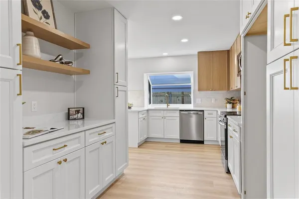 a kitchen with white cabinets and appliances