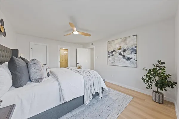 a bedroom with a large bed and a potted plant