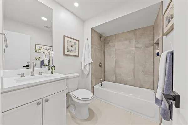 a bathroom with a bathtub shower sink vanity and toilet