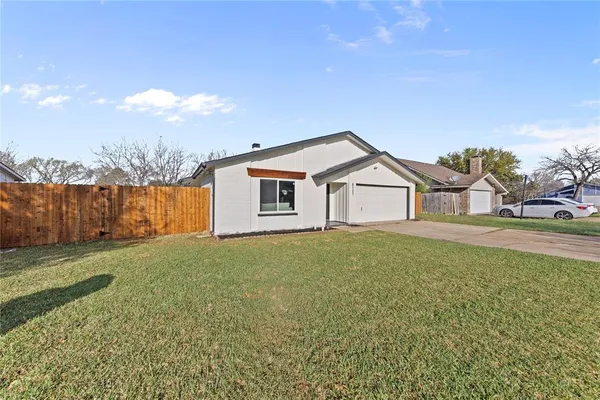 a view of a house with backyard and trees