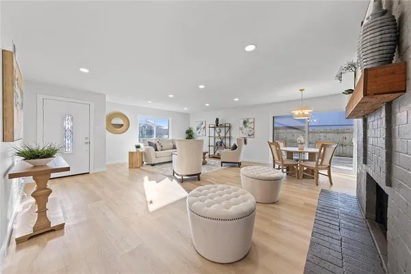 a living room with furniture a dining table and chairs with wooden floor